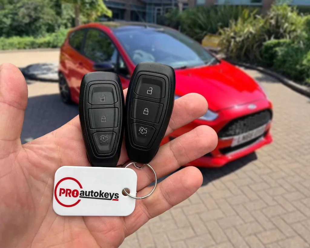 Two replacement Ford keys, cut and programmed on site, held in front of the car they were coded to